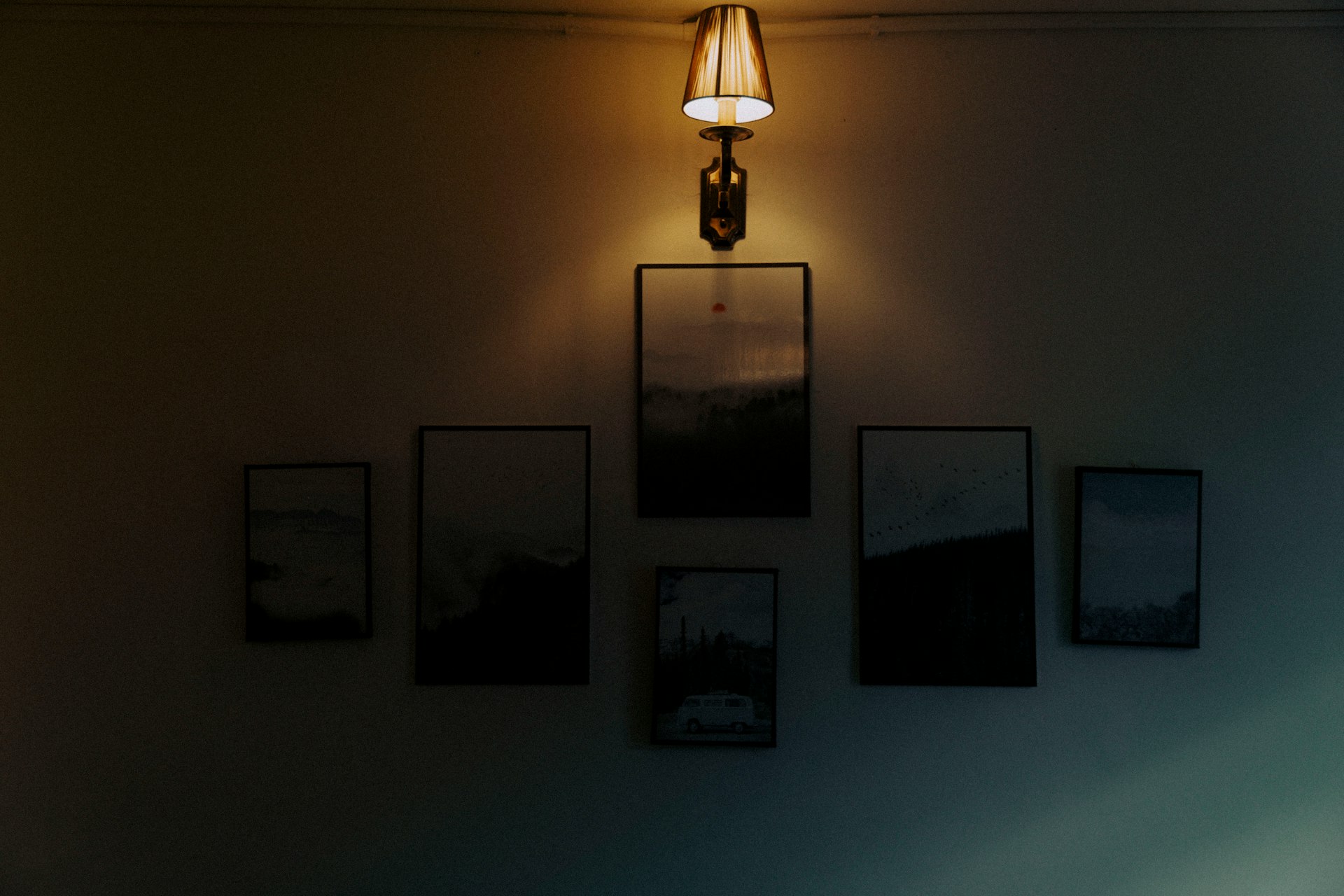a lamp that is on a wall next to pictures